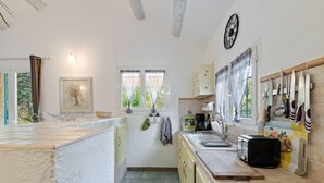Uma cozinha com uma janela grande, uma pia e um fogão.