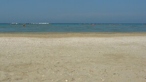 A beach with pebbly shore, calm sea, and distant rocky outcrops. - Countryside cottage in Pergola (Pergola)