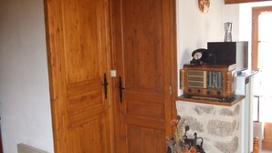 A wooden door, a vintage radio, and a decorative vase with flowers. - Rustic Retreat in Goutte-Claire (Sauvain)