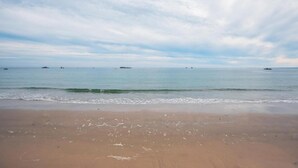 Ein Strand mit klarem Himmel und ruhiger See.