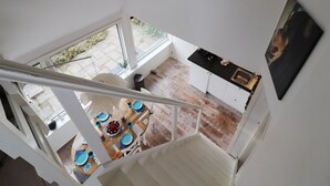Una cocina moderna con armarios blancos, encimera negra y un ventanal amplio.