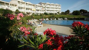 A hotel with a pool area, multiple balconies, and lush greenery. - Apartment with sea or pool views (Fouras)