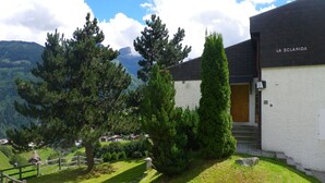 Ein Gebäude mit einem Schild, auf dem 'LA SCLARIDA' steht, und Blick auf eine gebirgige Landschaft.
