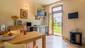 Una cocina moderna con comedor, televisor montado en la pared y vistas al exterior.
