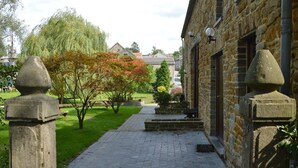 A stone building with a paved pathway leading to a bench area. - Luxury Holiday Haven in Sprimont (Sprimont)