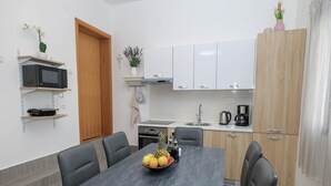 A modern kitchen with white cabinets, a microwave, and a coffee maker. - Luxury Apartment with heated pool in Starigrad (Starigrad)