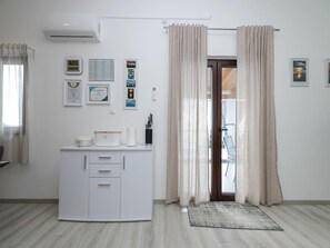 A modern, well-lit room with a white cabinet, a small rug, and a door with curtains.