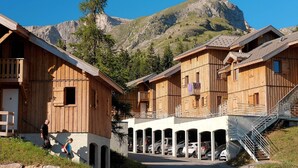 Une rangée de chalets en bois, avec une vue sur les montagnes en arrière-plan.