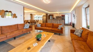 A modern living room with two sofas, a wooden coffee table, and a kitchen in the background.