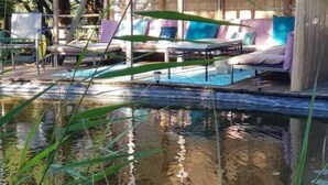 A poolside area with lounge chairs and a wooden deck. - Villa in Saint-Nexans with Private Heated Pool (Saint-Nexans)