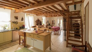A kitchen with wooden beams, a dining area with a table and chairs, and a staircase. - Villa in Saint-Nexans with Private Heated Pool (Saint-Nexans)