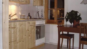 A kitchen with wooden cabinets, a sink, and a window with a view.