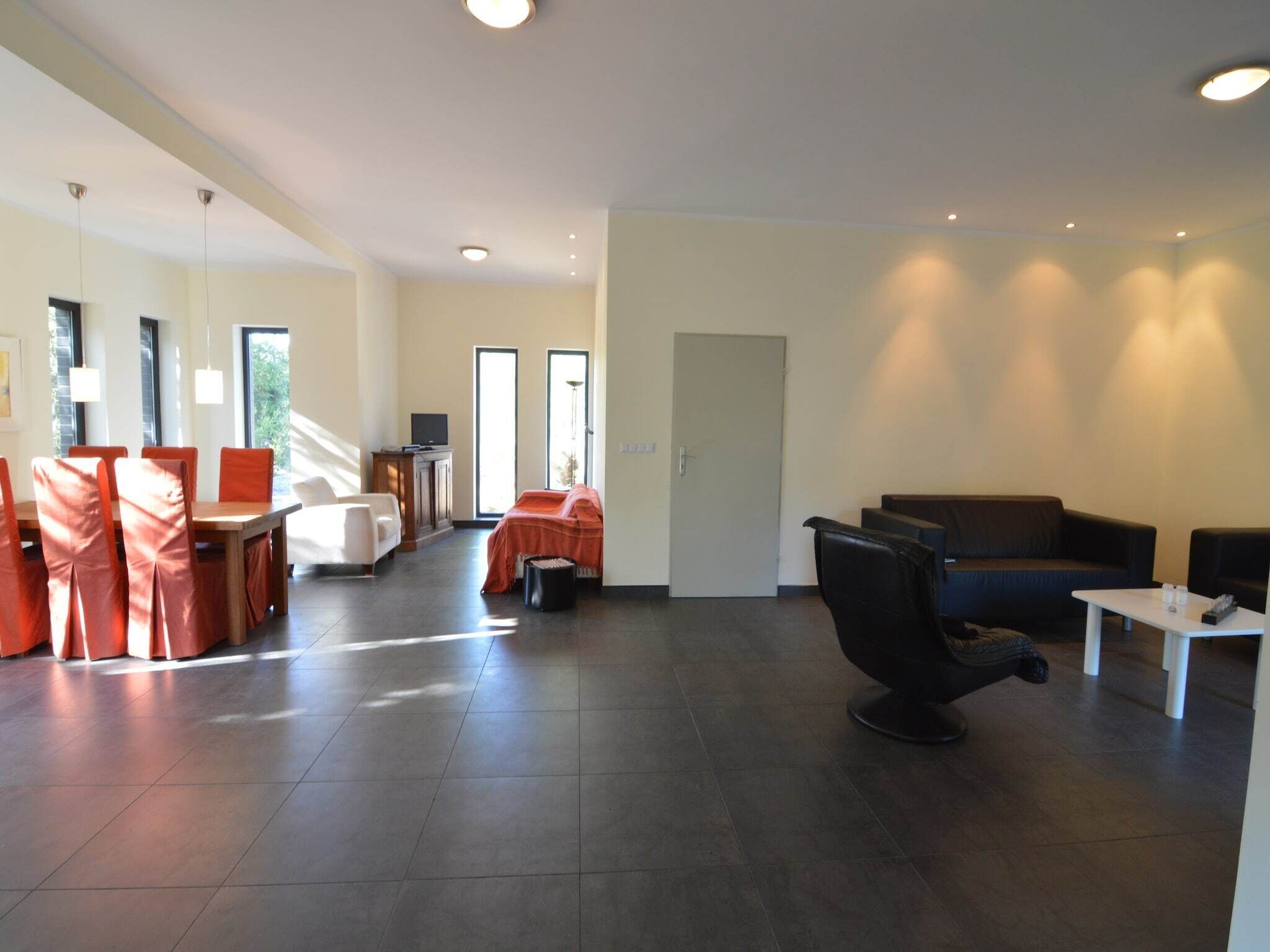 Un grand espace de vie comprenant une table à manger et des chaises, un canapé et une table basse.