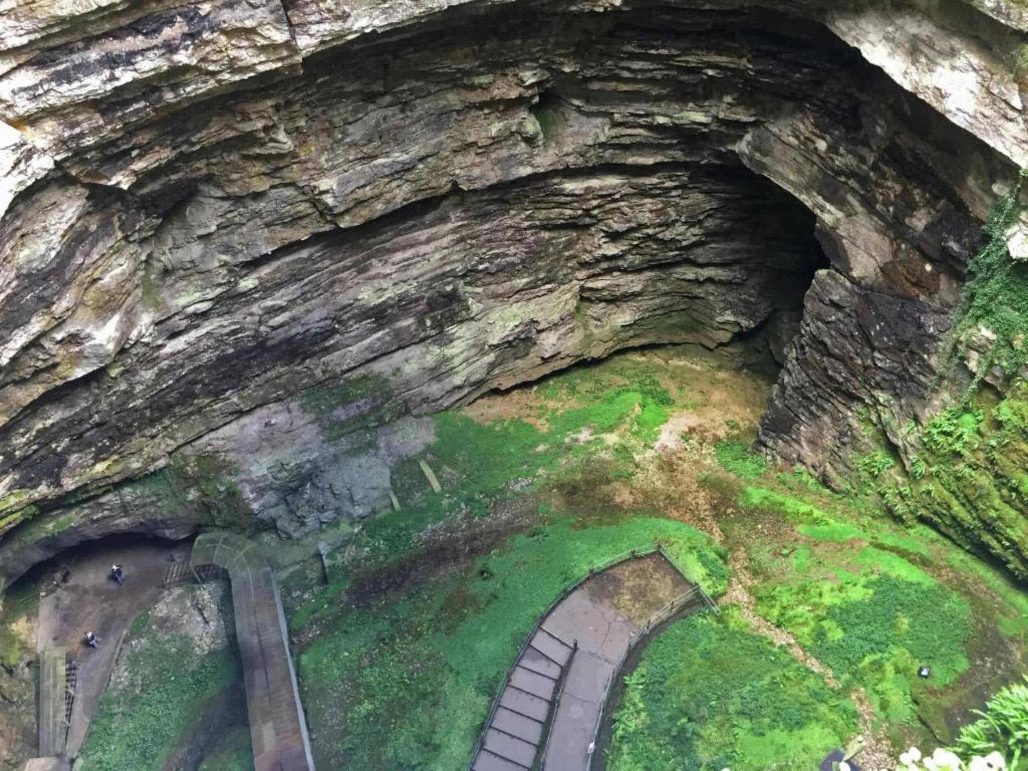 A cave entrance with a narrow pathway leading into it.