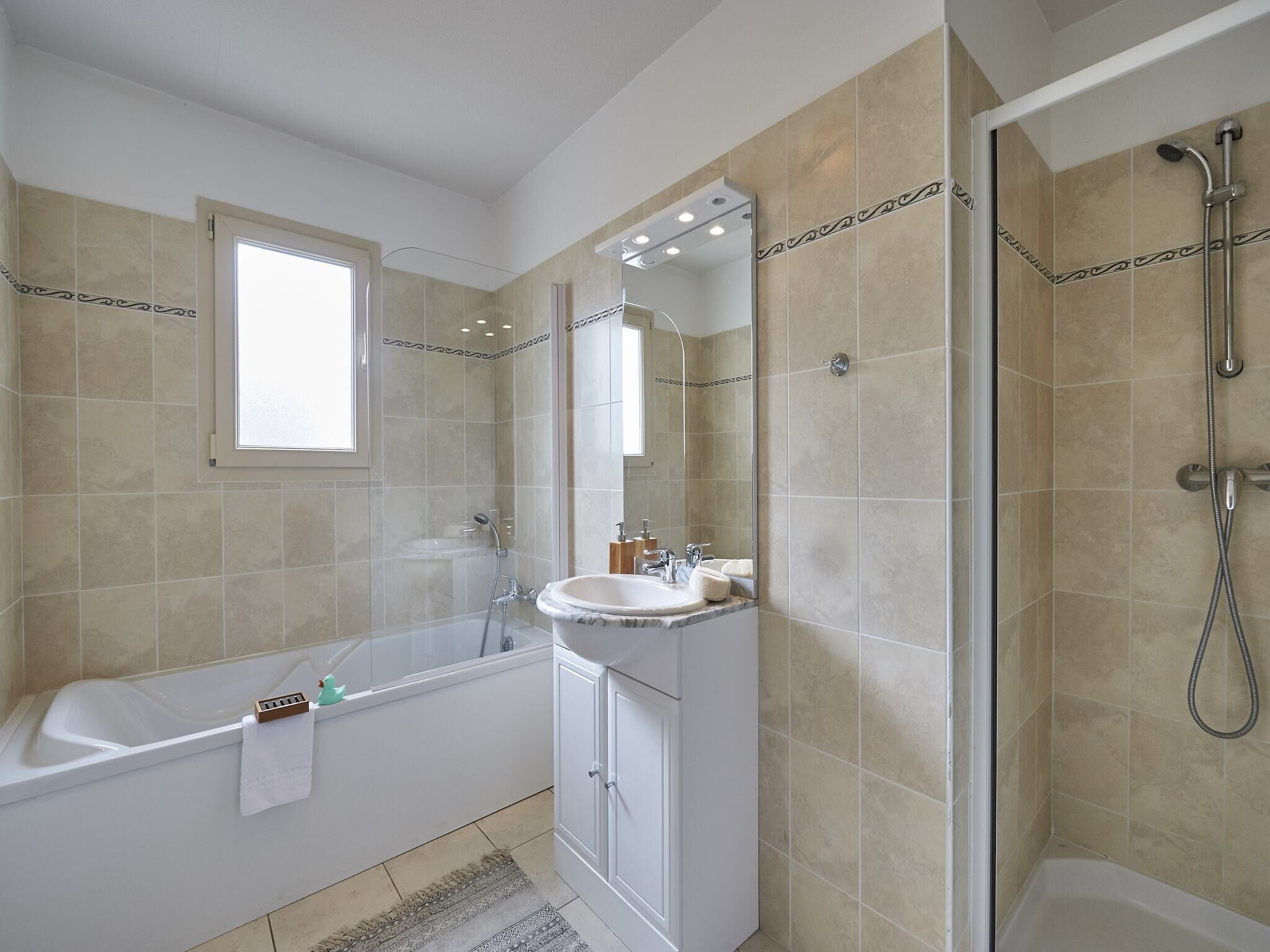 A modern bathroom with a bathtub, a sink, and a shower.