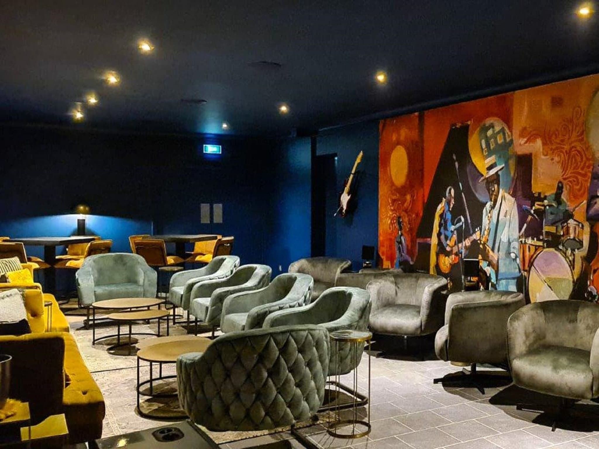 A lounge area with multiple seating options, including armchairs and sofas, arranged around a central table.
