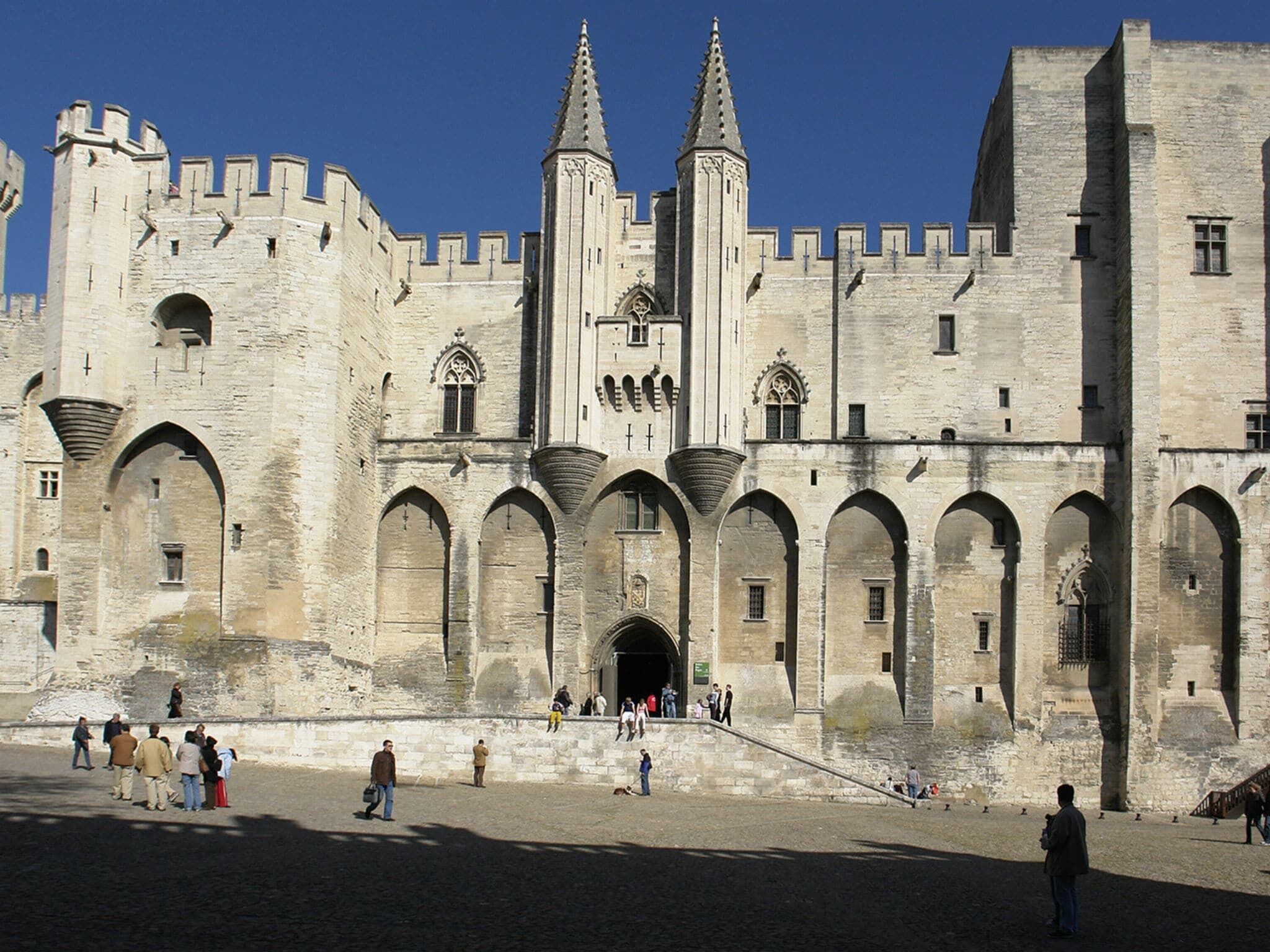 A historic stone building with multiple arches and towers.
