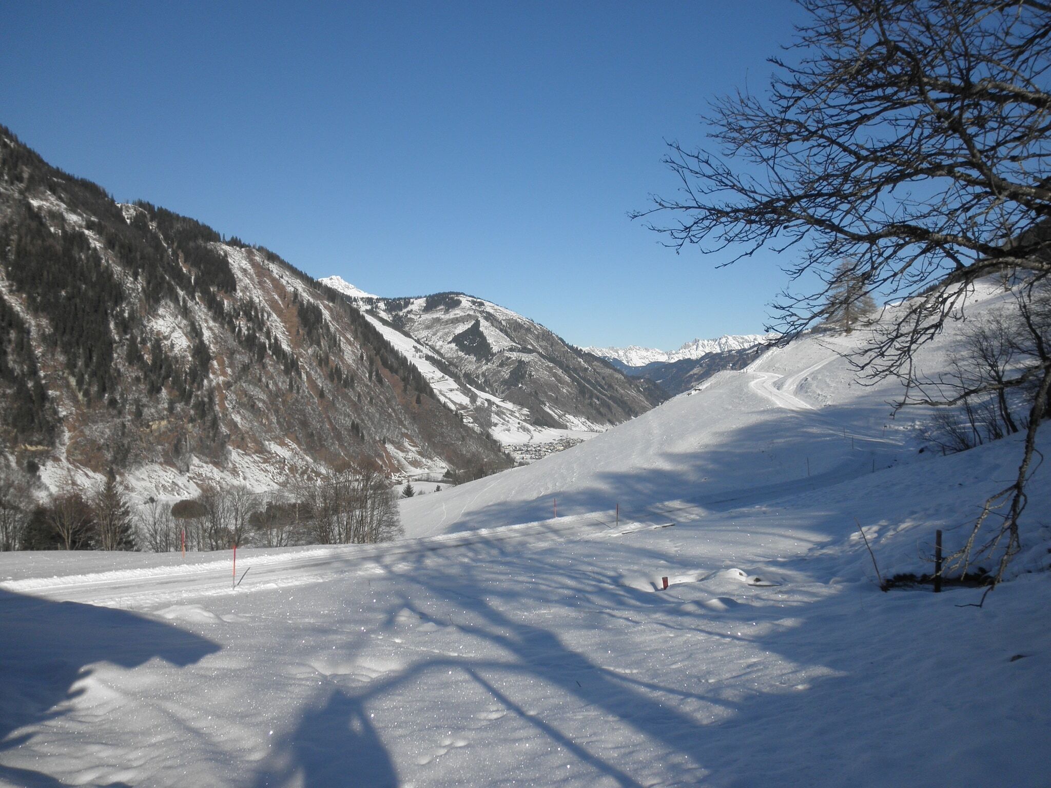 A snow-covered mountain road with a clear sky.