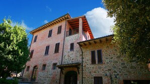 A traditional stone building with a brick upper level, a stone entrance, and a cobblestone courtyard.