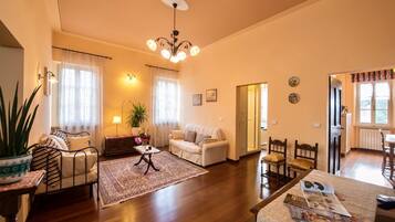 Ein gemütliches Wohnzimmer mit einer Couch, einem Couchtisch und einem Essbereich mit Stühlen.
