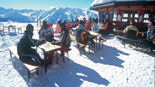 A group of people seated at tables outdoors in a snowy environment with mountains in the background. - Stylish Flats in Uderns near Ski Lift (Uderns)