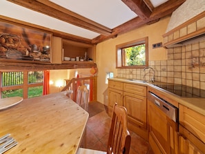 A wooden interior with a kitchen area, dining table, and chairs. - Bauernhaus nahe Langlingen Badesee (Langlingen-Hohnebostel)