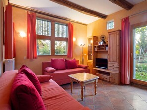A cozy living room with a sofa, a coffee table, and a TV stand. - Bauernhaus nahe Langlingen Badesee (Langlingen-Hohnebostel)