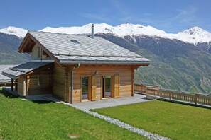 Situated in a mountainous area, this lodge offers a covered outdoor seating area and wooden doors.