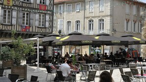 An outdoor café with tables and chairs, surrounded by buildings with traditional architecture. - Pretty Villa With Private Pool in Montadet France (Montadet)