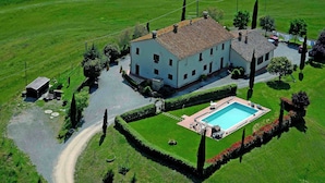 A large white building with a tiled roof, surrounded by well-maintained lawns and a swimming pool. - Spacious house in Pienza (Pienza)