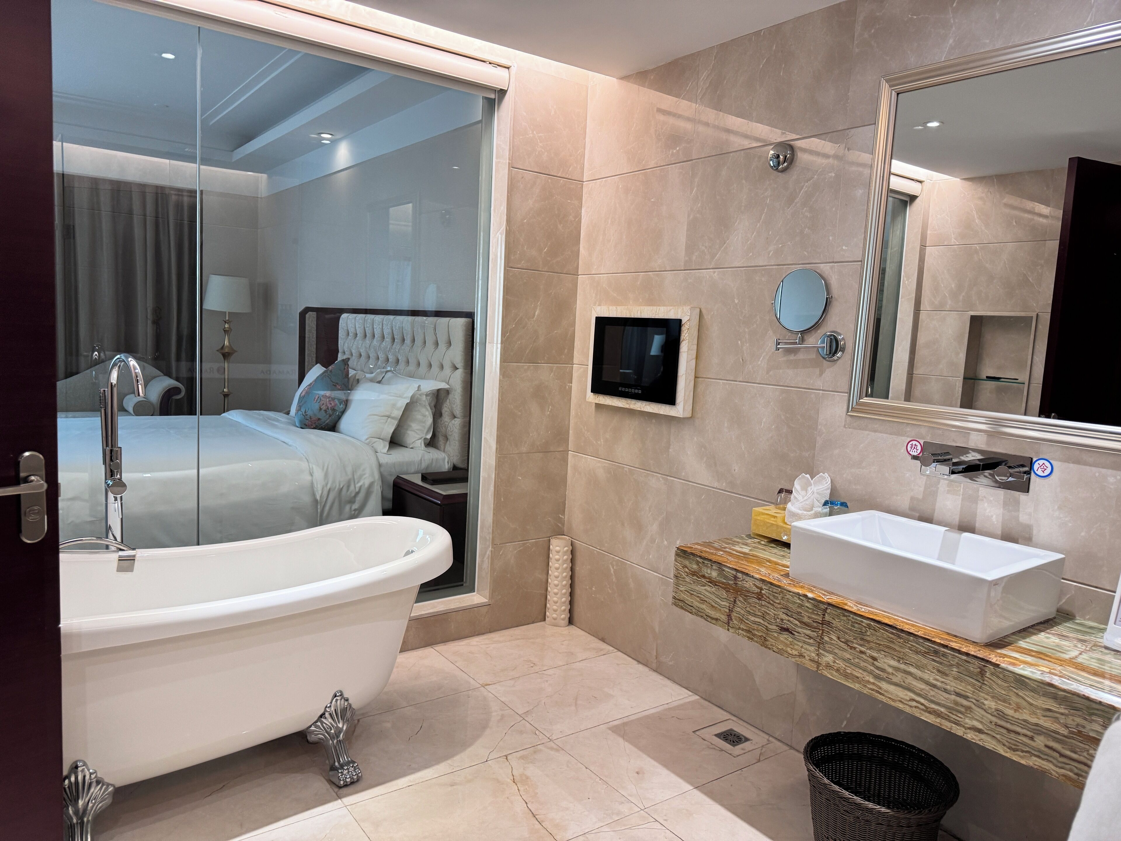 Un baño moderno con una bañera independiente, un tocador con lavamanos y un espejo grande.