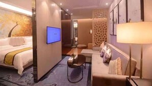 Una habitación de hotel moderna con cama, escritorio, sofá y televisor.