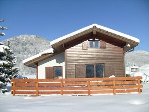 Cozy retreat with a gable and dormer window, surrounded by a traditional wooden fence.