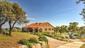 A stone house with a red roof, surrounded by greenery and a clear sky. - Farmhouse in Suvereto near Etruscan Coast (Suvereto)