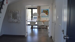 Un intérieur moderne comprenant un coin repas, un escalier et une porte.