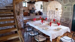 A rustic dining area with stone walls, wooden beams, and a long table set for a meal. - Villa on Krk with Pool and Outdoor Kitchen (Krk - Malinska)