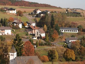 A rural village with houses, a church, and a solar panel building.