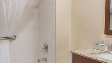A bathroom with a bathtub, toilet, and a sink with a mirror.