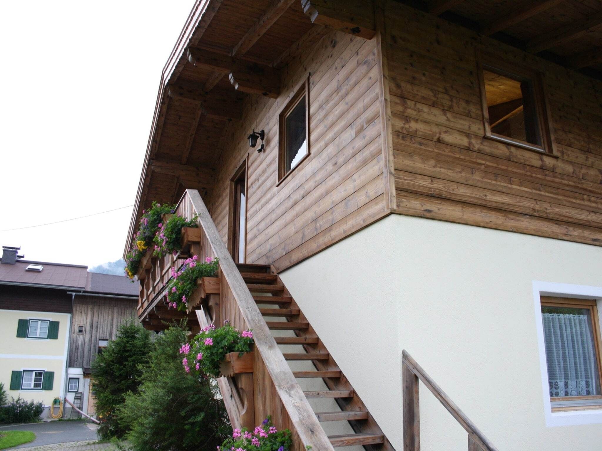 Ein Holzhaus mit einer Holztreppe, die zu einem Balkon führt.