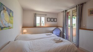 A hotel room with two beds, a chair, a painting, and a window with curtains. - Pavilion Stay in Dordogne (St. Medard D'excideuil)