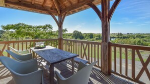 A wooden deck with a table and chairs, overlooking a scenic landscape. - Pavilion Stay in Dordogne (St. Medard D'excideuil)