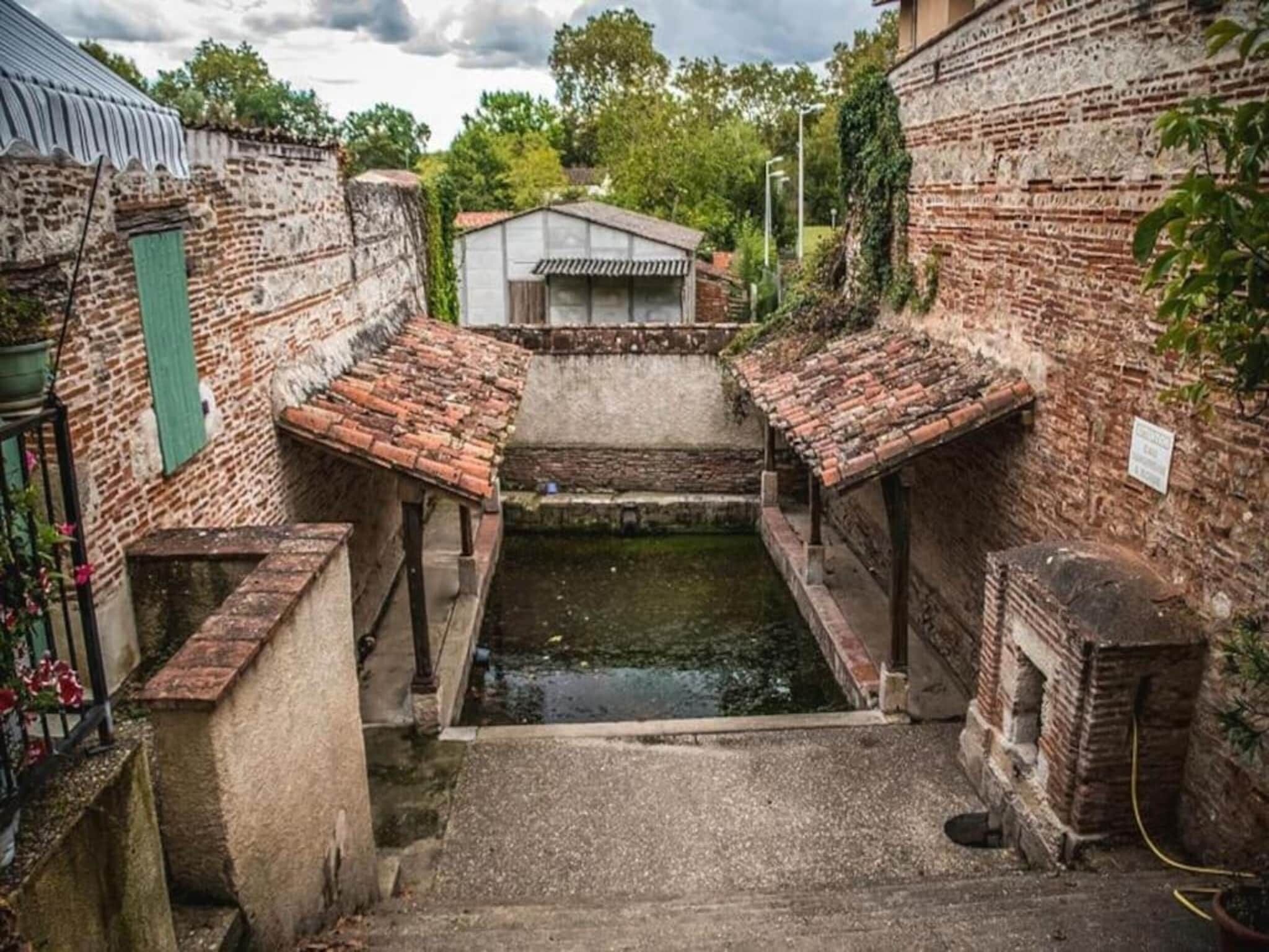 Un callejón estrecho con paredes de ladrillo y un pequeño canal de agua.