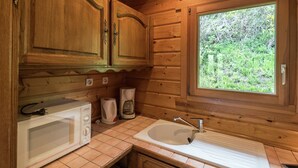 A wooden cabin-style kitchen with a built-in microwave, coffee maker, and sink. - Chalet in La Bresse near Forest & Lake (La Bresse)