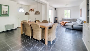 Een moderne woonkamer met een eethoek, een open haard en een bank.