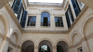 A classical building with arched windows and a central skylight.