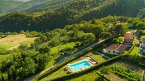 Zona residencial con piscina, rodeada de exuberante vegetación y colinas al fondo.