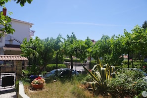 Guests can enjoy a serene garden with a variety of plants and a potted flower arrangement.