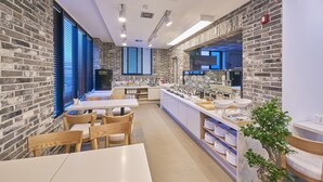 A modern restaurant with brick walls, wooden tables, and a central counter with food displays. - Madrid Hotel Gwangju (Gwangju)