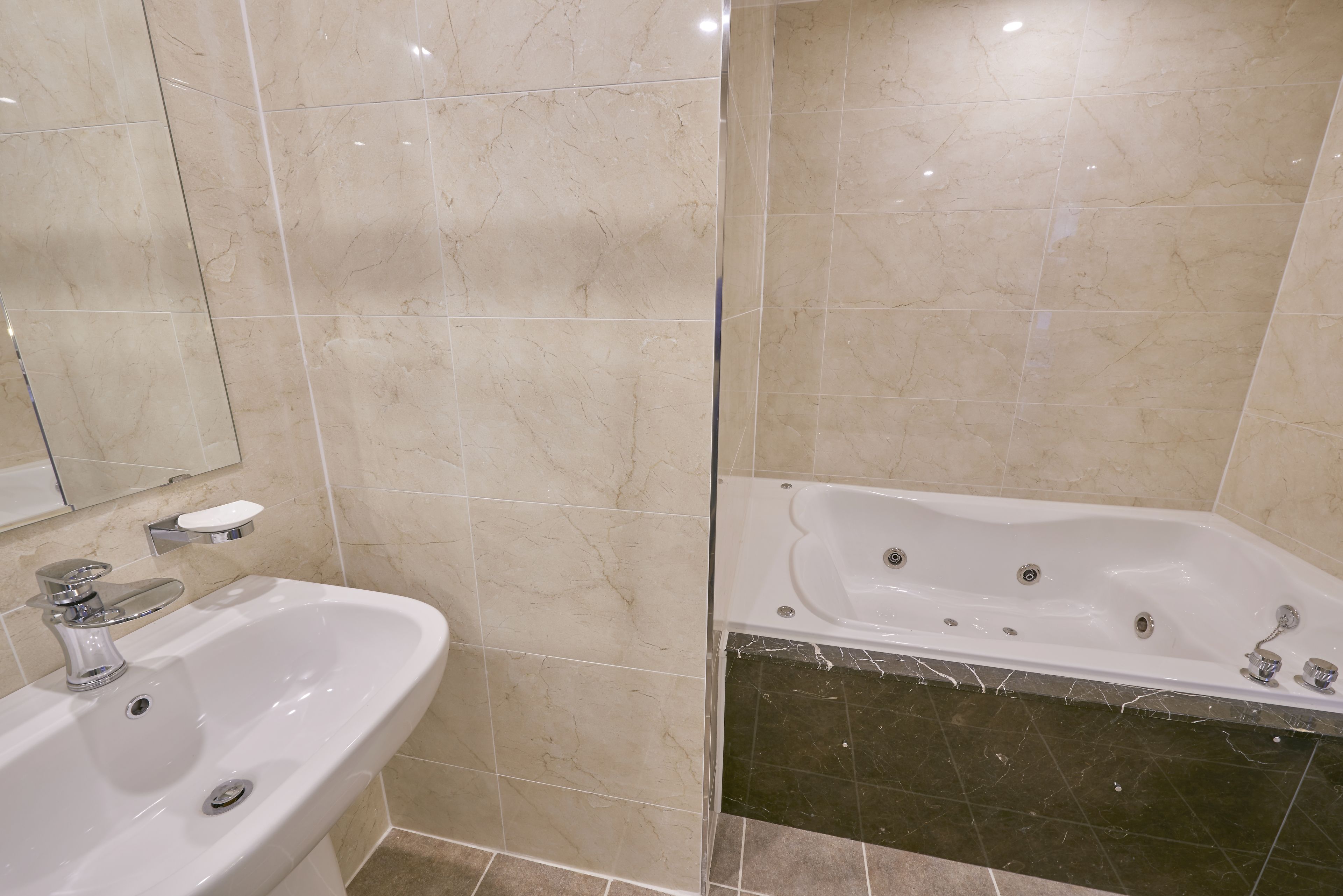 A bathroom with a white sink, a mirror, and a bathtub.