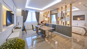 A modern hotel room with a dining area, a sofa, a TV, and a bed. - Madrid Hotel Gwangju (Gwangju)